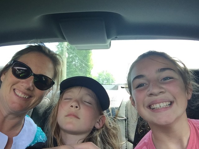 Three girls in the backseat of a car