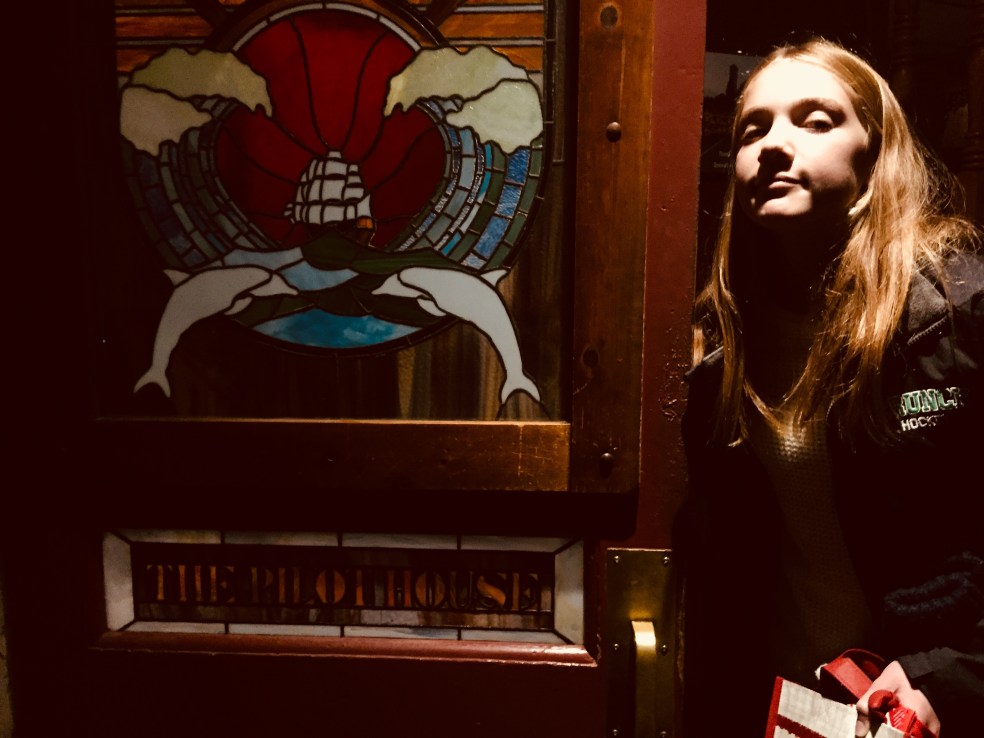 Clare at the stained glass door to the bar