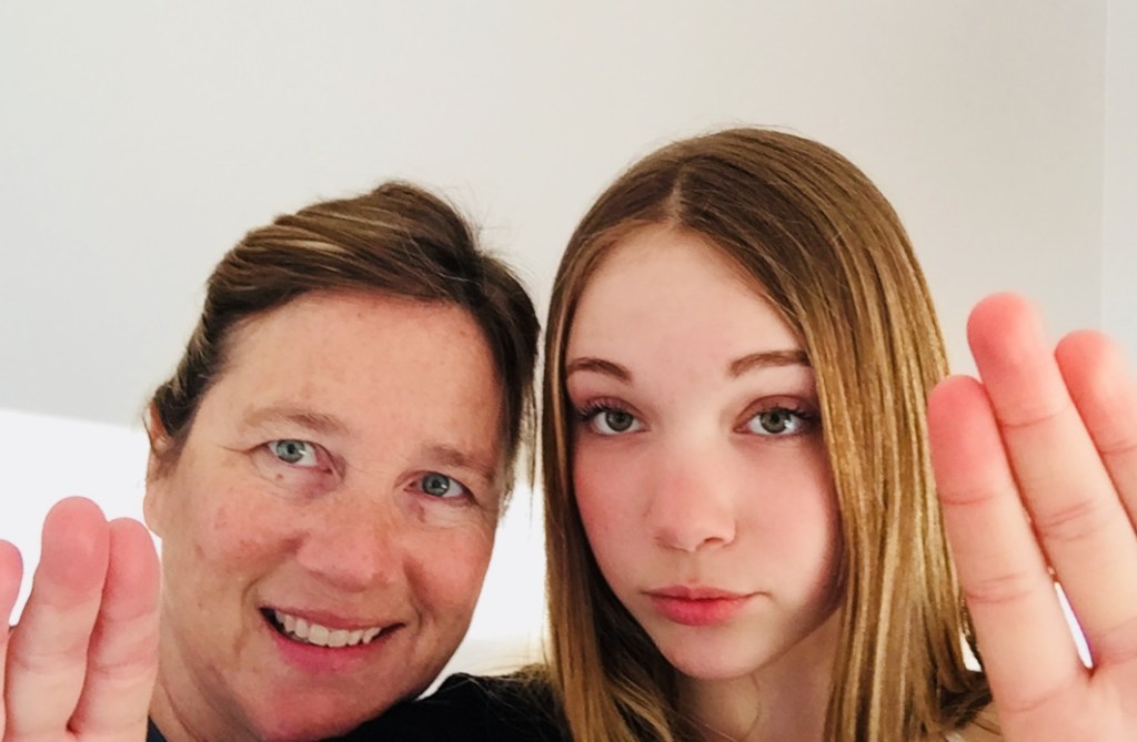 Author and her daughter holding their hands high in solidarity for International Women's Day