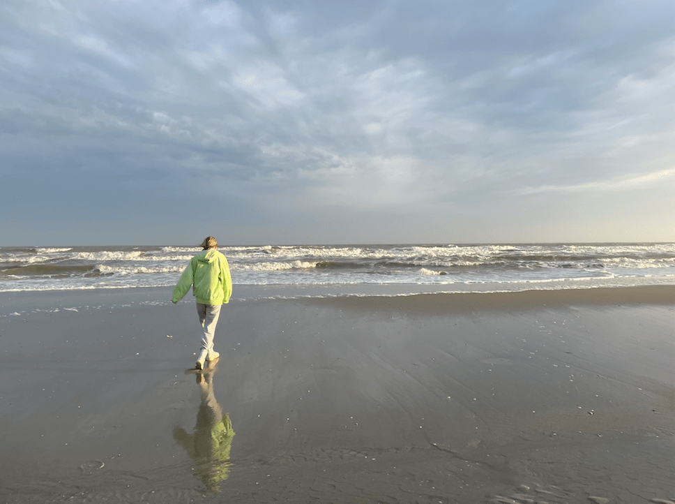 Girl walking on the beach in the rain