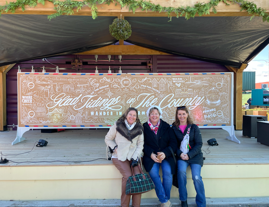 Author and her girlfriends in front of a Christmas sign
