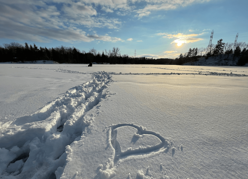 Heart drawn in the snow on a frozen lake