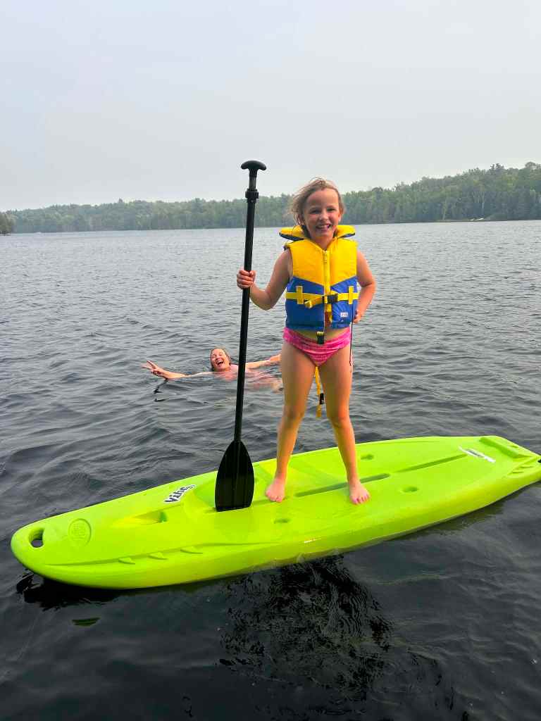 Girl striking a power pose on a paddleboard